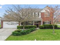Charming two-story brick home featuring a well-manicured lawn and attached two-car garage at 5817 Thompson Park Blvd, Indianapolis, IN 46237
