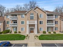 Charming condo building featuring a manicured lawn, complemented by private balconies on each level at 6516 Emerald Hill Ct # 310, Indianapolis, IN 46237
