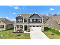 Charming two-story home featuring a brick facade and a well-manicured lawn with an attached two-car garage at 6622 Cardiff Cir, McCordsville, IN 46055