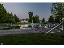 Beautiful property featuring a serene pond and fountain, accessible via a charming bridge at 8155 Hunt Club Rd, Zionsville, IN 46077