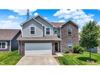 Charming two-story home showcasing a brick and vinyl exterior, well-manicured lawn, and an attached two-car garage at 950 Redwood Dr, Franklin, IN 46131