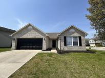 Charming single-story home with a brick facade, black garage door, and well-manicured lawn at 2344 Orchard Creek Dr, Columbus, IN 47201