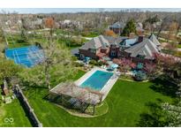 Aerial image of a brick home with a pool and covered patio in a well-manicured yard at 290 Breakwater Dr, Fishers, IN 46037