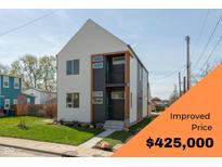 Modern two-story home featuring a balcony, sleek design, and well-manicured lawn, offered at an improved price at 315 E Minnesota St, Indianapolis, IN 46225