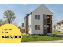Modern two-story home featuring white siding, black accents, and a small balcony at 315 E Minnesota St, Indianapolis, IN 46225