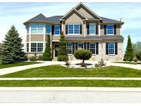A two-story home with brick and siding, complemented by green grass and sidewalk at 4414 Hickory Grove Blvd, Greenwood, IN 46143