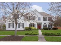 Charming two-story home with painted brick, manicured lawn, and a vibrant red front door at 443 Quincy Pl, Westfield, IN 46074
