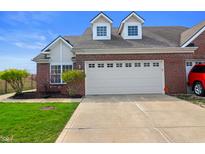 Beautiful home featuring a red brick exterior, white garage door, and well-maintained front yard at 4916 Franklin Villas Dr, Indianapolis, IN 46237