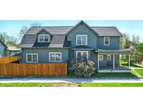 Charming two-story home with a covered porch and a well-maintained front yard and a small fence at 516 S 10Th St, Noblesville, IN 46060