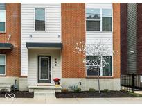Attractive townhome entrance featuring a decorative wreath, seasonal plantings, and brick and siding accents at 741 Bates St, Indianapolis, IN 46202