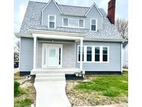 Charming two-story home featuring gray siding, white trim, and a welcoming front porch at 902 E 31St St, Anderson, IN 46016