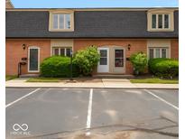 Two-story townhouse with brick exterior, neutral trim, black roof, and parking at 1131 Canterbury S Sq, Indianapolis, IN 46260