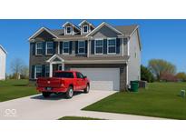 Beautiful two-story home with gray siding, brick accents, blue shutters, well-manicured lawn, and a red pickup in the driveway at 1573 Vera Blvd, Danville, IN 46122