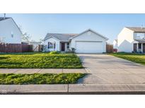 Charming single-story home with a well-maintained lawn and a paved driveway leading to the garage at 1696 Carlton Dr, Greenfield, IN 46140