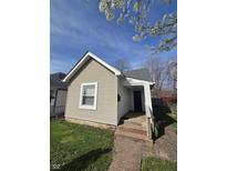 Charming single story home featuring light beige siding and a quaint brick walkway leading to the front entrance at 1710 Thaddeus St, Indianapolis, IN 46203