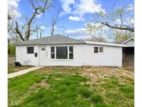 Quaint single-story home featuring a well-lit exterior, a gray roof and a manicured lawn at 1842 W Kessler Blvd N Dr, Indianapolis, IN 46228