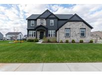 Beautiful two-story home with stone and gray siding, a well-manicured lawn, and professional landscaping at 2280 Meadow Crk, Avon, IN 46123