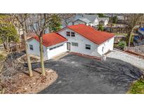 Aerial view of a white home with a red roof, an attached garage, and a spacious paved driveway at 2469 Cape Henry Ct, Cicero, IN 46034