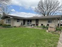 Charming single-story home featuring a well-manicured lawn and stone accents at 3250 Hillcrest Dr, Columbus, IN 47203