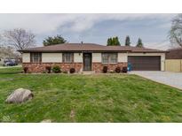 Charming ranch-style home with a well-maintained lawn, brick accents, and attached garage at 5510 Chelsea Rd, Indianapolis, IN 46241