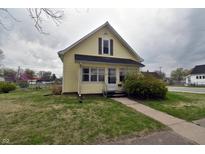 Charming yellow two-story home with a cozy front porch and well-maintained lawn at 609 E Columbus St, Martinsville, IN 46151