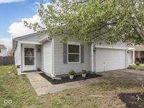 Charming home exterior with gray siding, a two car garage and well-kept landscaping at 6212 Monteo Dr, Indianapolis, IN 46217