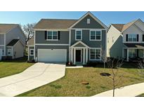 Charming two-story home with gray siding, attached two-car garage, and well-manicured front lawn at 6917 Wheatley Rd, Whitestown, IN 46075