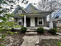 Inviting home featuring a cozy front porch with classic white pillars and neutral siding at 1626 S State Ave, Indianapolis, IN 46203