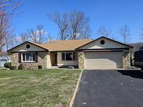 Charming ranch-style home with a stone facade, two-car garage, and well-maintained lawn at 1647 S Plateau Cir, Martinsville, IN 46151