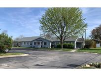 Charming single-story home featuring light blue siding, white trim, and a well-maintained lawn, beneath a bright sky at 2715 Prosperity Dr, Columbus, IN 47201