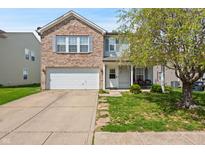 Charming two-story home with a brick and siding exterior and a well-maintained front yard and a two-car garage at 350 Springfield Cir, Greenwood, IN 46143