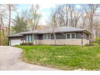 Ranch home featuring stone accents and a lush front lawn at 3636 E 71St St, Indianapolis, IN 46220