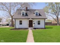 Charming two-story home featuring a manicured lawn, light siding, and a welcoming pathway to the front door at 402 N 19Th Ave, Beech Grove, IN 46107