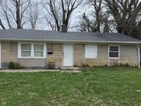Single story home featuring tan siding, a gray shingled roof, and a well-maintained lawn at 5858 E 44Th St, Indianapolis, IN 46226