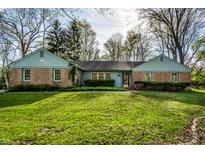 Charming brick home with a well-manicured lawn and beautiful landscaping at 6911 N Tuxedo St, Indianapolis, IN 46220