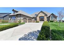Stunning home with stone accents, a well-manicured lawn, and a spacious three-car garage at 7128 Trail Ridge Ln, Indianapolis, IN 46259