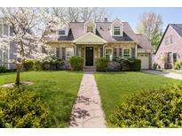 Charming brick home with beautiful front lawn, landscaping, and welcoming stone walkway at 908 N Bolton Ave, Indianapolis, IN 46219