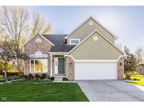 Charming two-story home featuring a landscaped front yard and attached two car garage at 10775 Northhampton Dr, Fishers, IN 46038
