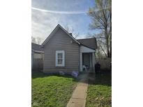 Cozy home featuring a neatly maintained lawn, mature trees, and neutral colored siding at 1343 W 33Rd St, Indianapolis, IN 46208
