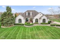 Elegant white brick home featuring arched windows and a beautifully landscaped front yard at 1583 E Osprey Dr, Greenfield, IN 46140