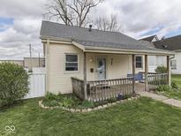 Charming home featuring a quaint front porch, manicured lawn, and inviting curb appeal on a partially cloudy day at 213 N Walnut St, Edinburgh, IN 46124