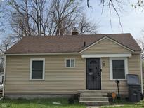 Cozy single-story home with tan siding, a brown roof, and a secure front door at 3101 N Temple Ave, Indianapolis, IN 46218
