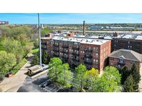 Brick exterior of the H. Lauter Lofts, featuring private balconies and a visible parking lot at 55 S Harding St # 301, Indianapolis, IN 46222