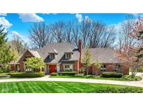 Charming brick home boasts a well-manicured lawn, mature trees, and a circular driveway at 7545 Chablis Cir, Indianapolis, IN 46278
