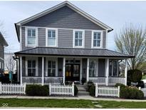 Charming two-story home with a covered front porch and white picket fence at 7638 Beekman Ter, Zionsville, IN 46077