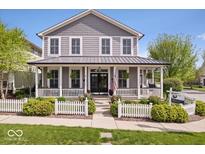 Charming two-story home with a inviting front porch, white picket fence, and lush lawn at 7638 Beekman Ter, Zionsville, IN 46077