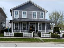 Charming two-story home featuring a welcoming front porch with a white picket fence and attractive landscaping at 7638 Beekman Ter, Zionsville, IN 46077