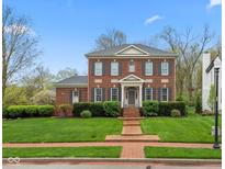 Classic brick home boasts manicured lawn, symmetrical design, and inviting entrance at 8027 Heyward Dr, Indianapolis, IN 46250