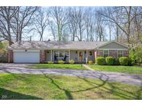 Charming single story home featuring a brick accent, inviting front porch, and manicured lawn at 1109 Oakwood Trl, Indianapolis, IN 46260