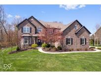 Charming two-story brick home with landscaped front yard and basketball court in driveway at 11410 Sea Side Dr, Fishers, IN 46040